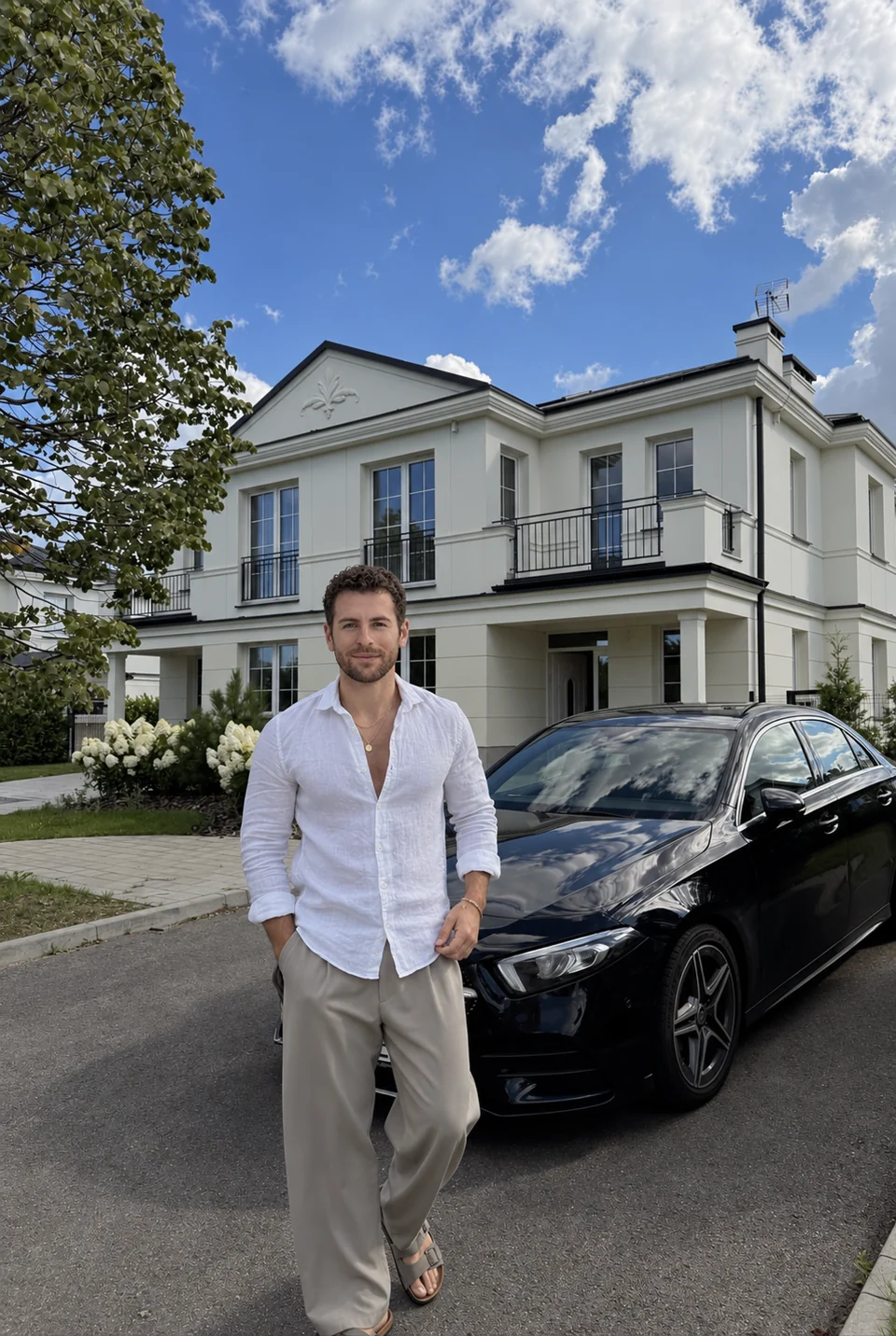 Joseph standing beside a car outside a house